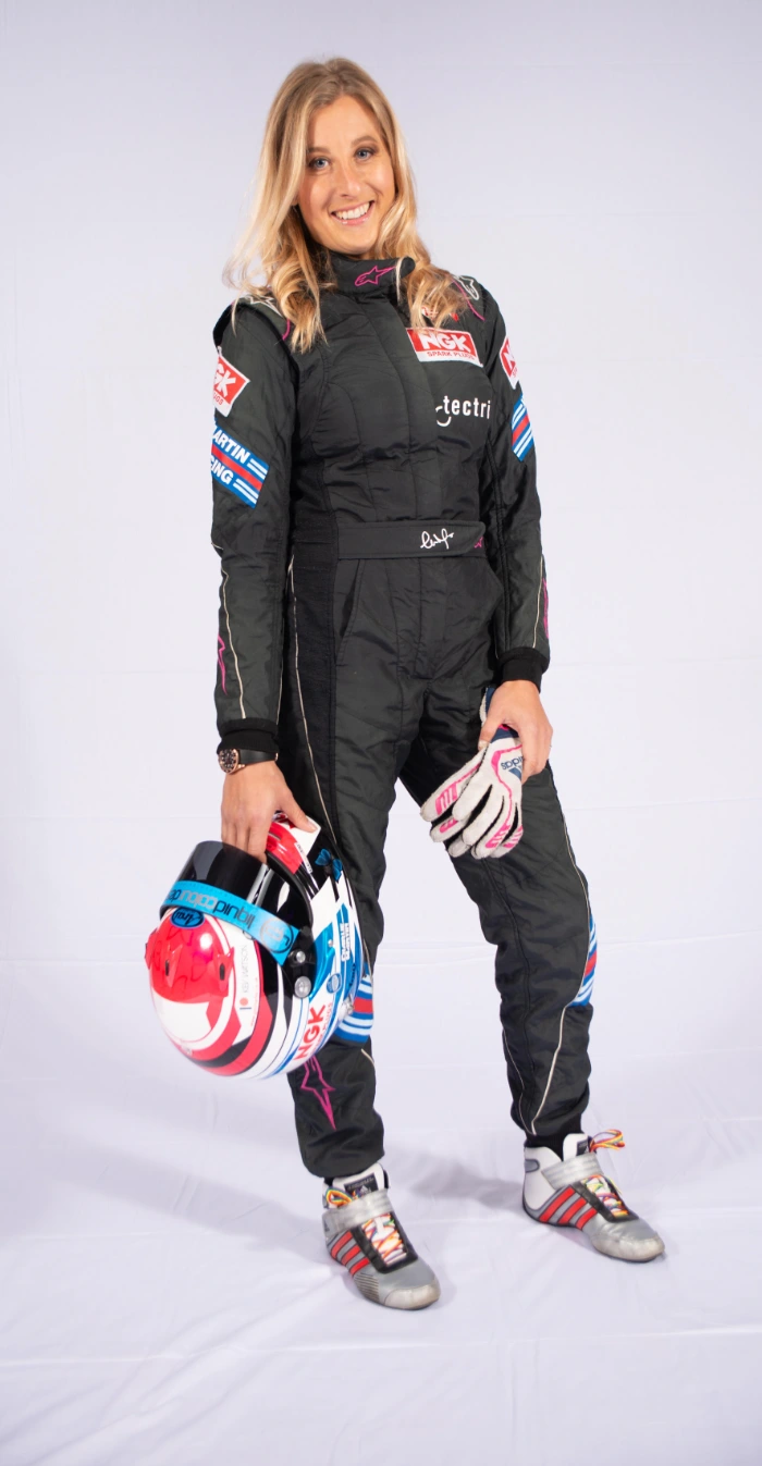 Trans race car driver Charlie Martin posing in her racing outfit sponsored by Facialteam