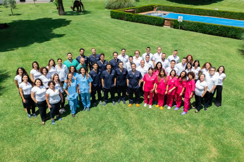 The entire team of Facialteam posing for a group photo, the team counts over 50 facial feminization surgery specialists posing at Facialteam's facial feminization clinic in Marbella, Spain..