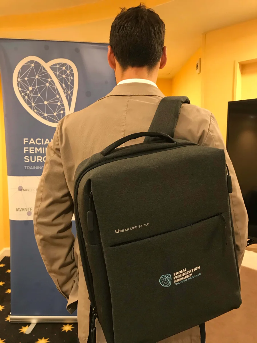Facialteam FFS Surgeon doctor Luis Capitán showing a backpack with the logo of Facialteam Training & Education embroided on it.
