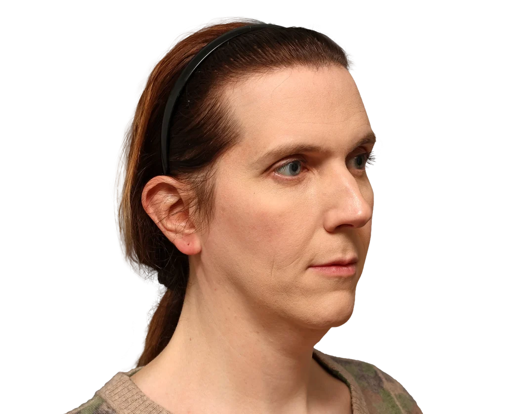 Side profile of a woman with light skin wearing a black headband, looking to the right, neutral expression.