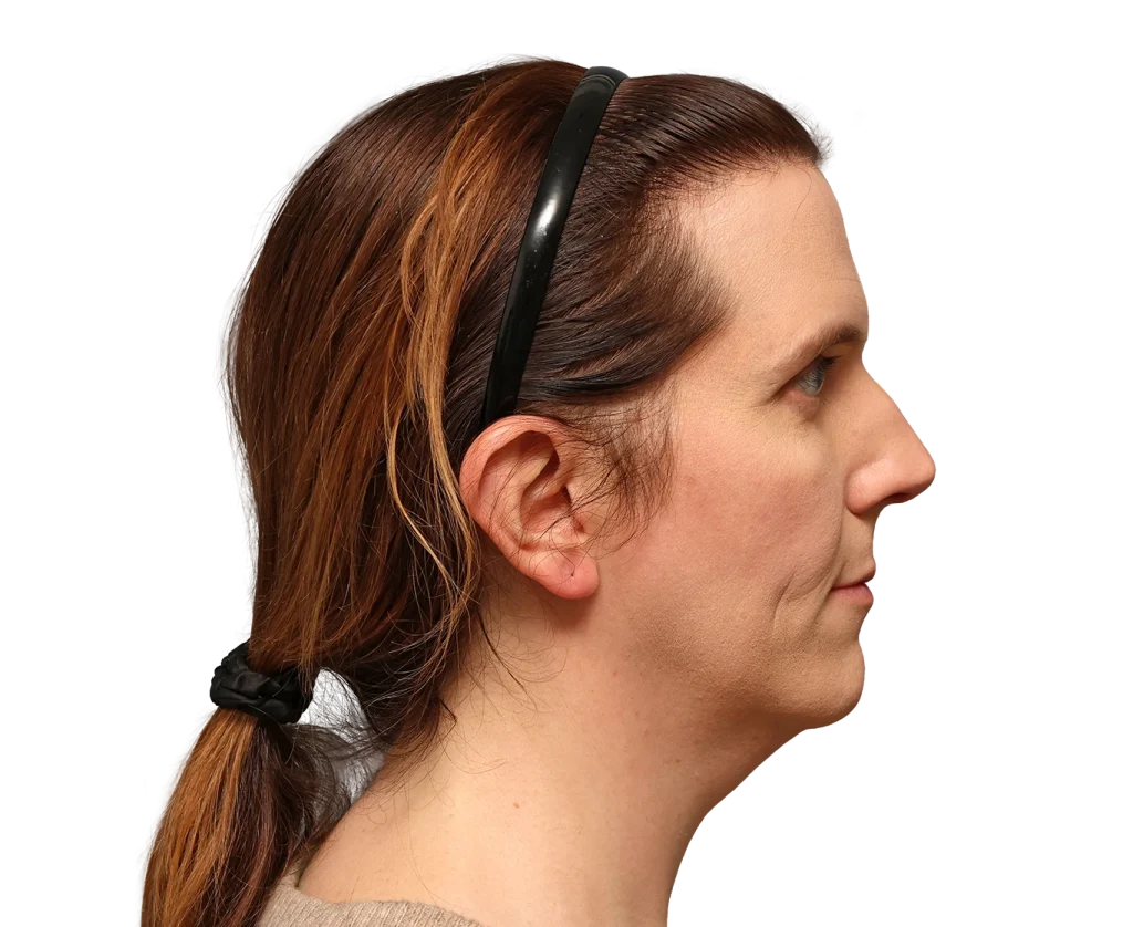 Side profile of a woman with brown hair tied in a low ponytail, wearing black sunglasses on her head.