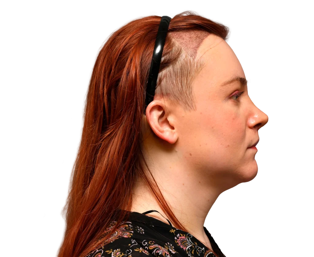 Side profile of Mia with red hair and an undercut, wearing a black headband.”