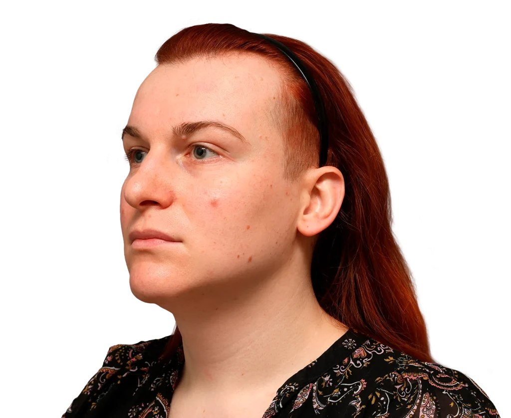 Portrait of Mia with red hair and a black headband, shown in left-profile against a black background.