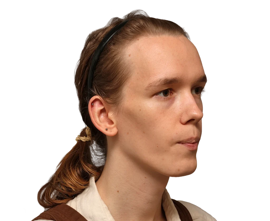 Side profile of a young Zoey with light brown hair in a low ponytail, wearing a black headband.