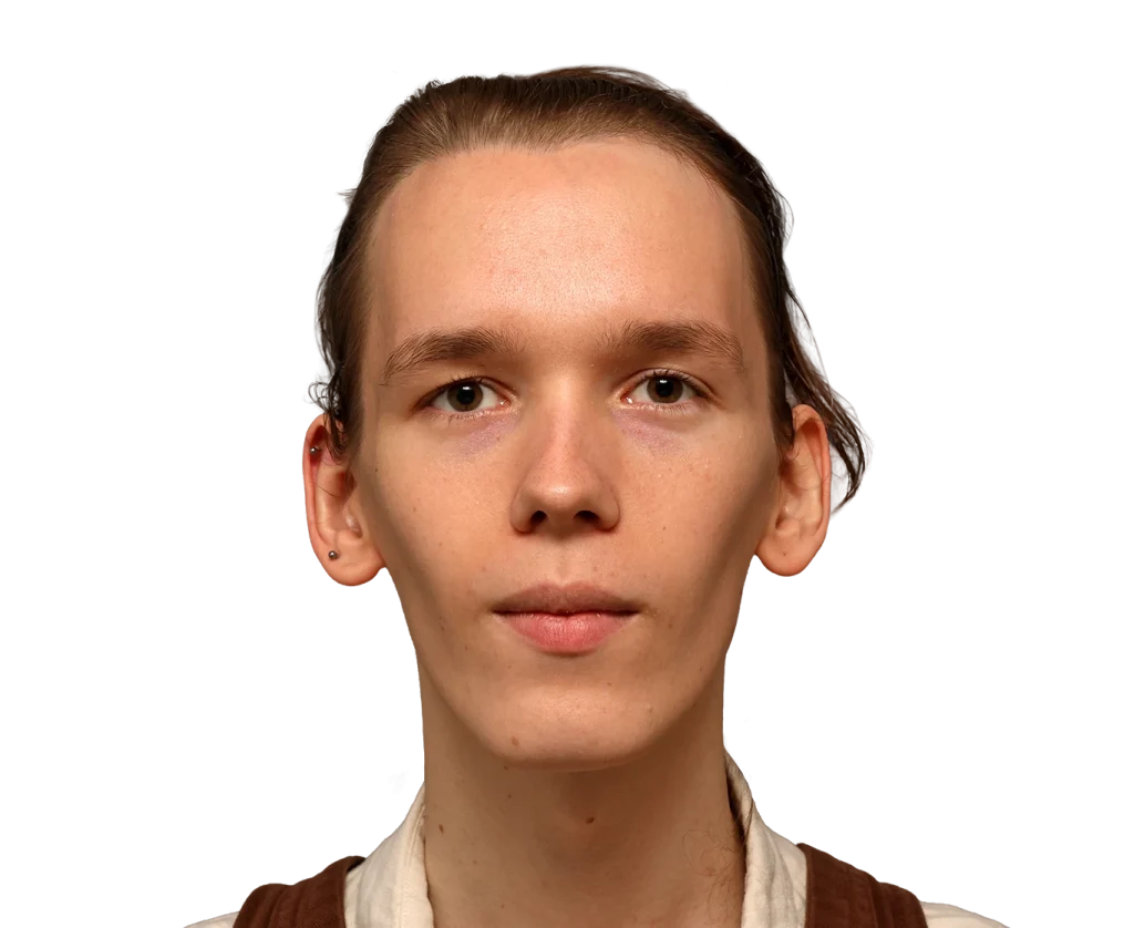Front-facing portrait of a young Zoey with light brown hair tied back, wearing a beige top with brown straps against a black background.