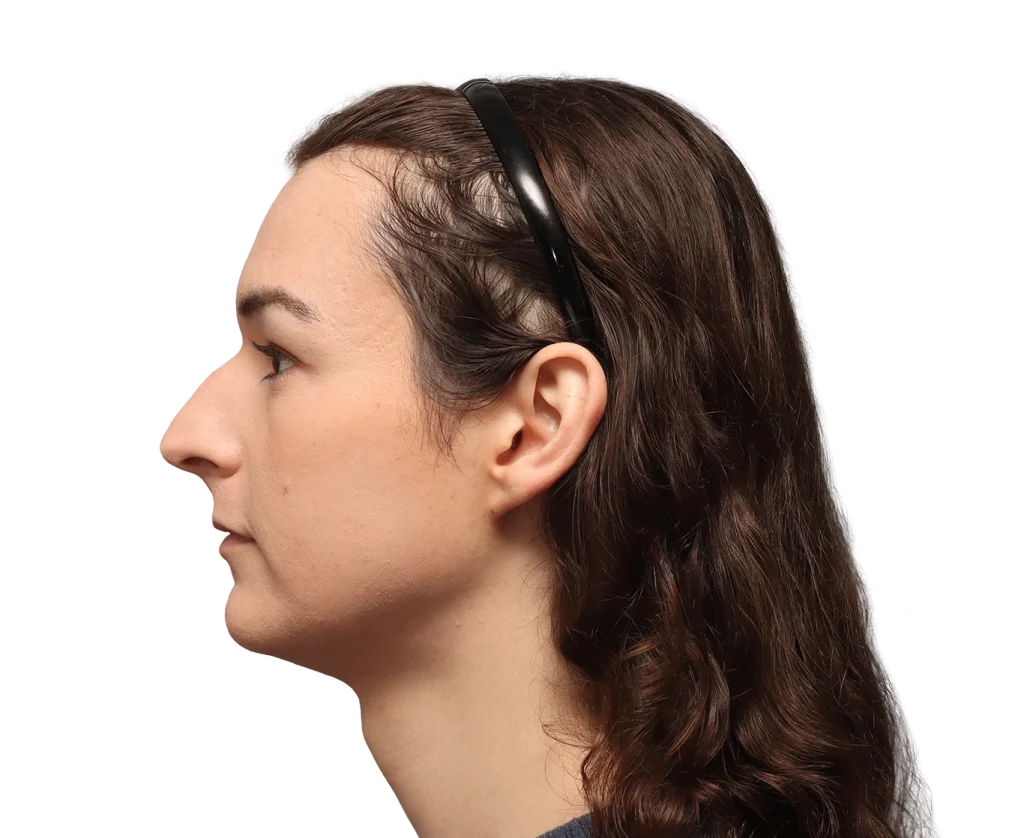 Profile view of a woman with brown hair wearing a black headband, facing left.